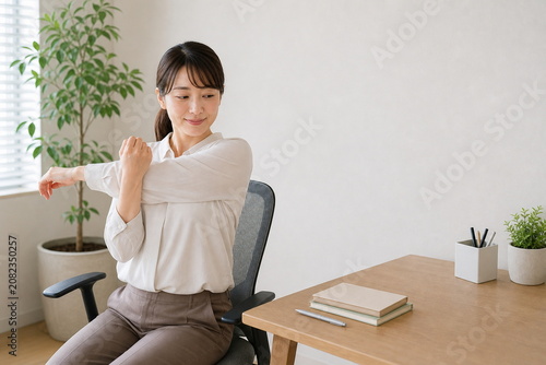 椅子に座って軽いストレッチをする日本人女性