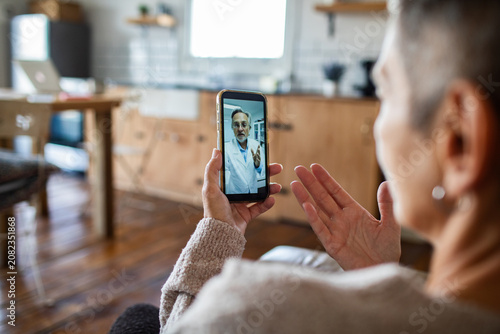 Fotografía Woman having telehealth video call with doctor at home