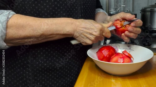 Close Up of Fresh Ripe Red Tomato Peeling Process with Hands Using Paring Knife Over Bowl During Home Kitchen Food Preparation for Homemade Cooking