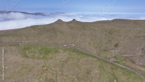 Drone shot of 4x4 vehicle driving on small road in Faroe Islands