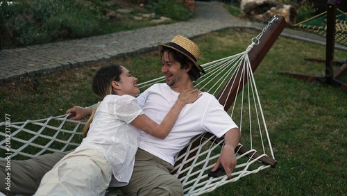 Slika na platnu Young couple unwinding in a hammock during a relaxing summer getaway