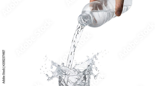 Tableau sur toile Hand pouring water from a clear plastic bottle into a glass isolated on transpar