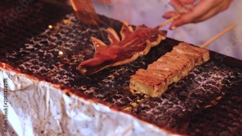 Ikayaki, Grilled roasted Squid with sauce - popular Japanese Street Food, variety of different traditional food snack selection in Tokyo, Japan, street market with local vendor stalls cooking