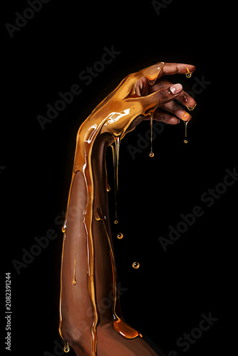 arm reaching up, dripping honey; isolated on black