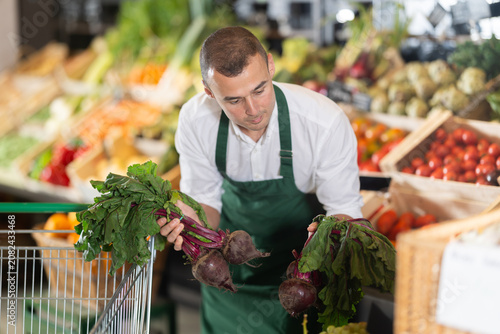 фотографія Man supermarket worker with vegetables in hands
