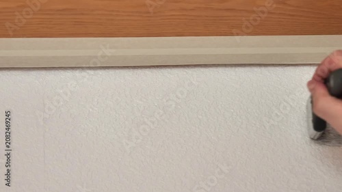 Wall renovation and painting.Close-up of a hand holding a paintbrush against a white wall background. 4k footage