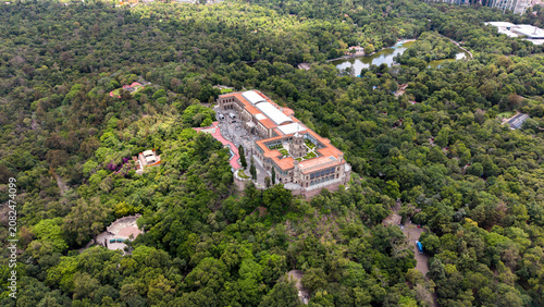 Aerial view of Chapultepec Castle and Mexico City skyline. Drone shot of historic castle, lush green park and skyscrapers on Paseo de la Reforma in CDMX.