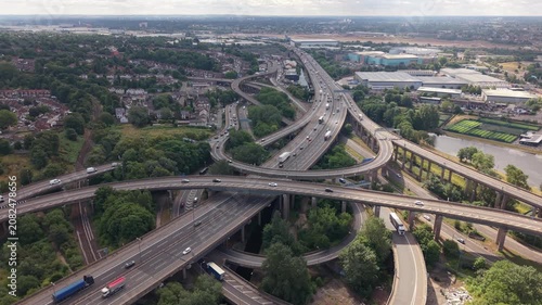 Cinematic drone flight over the world-famous Spaghetti Junction motorway interchange in Birmingham, England. The aerial perspective showcases the intricate multi-level M6 highway system with sweeping 