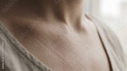 Extreme macro shot of human neck area during deep breathing exercise collarbone motion