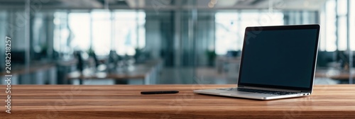 Laptop and computer on a wooden desk in a modern office workspace with blank screen