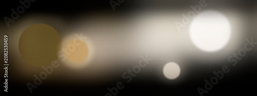 Obraz na plátně Out-of-focus bokeh lights glow against a dark roadway at dusk, creating a dreamy, peaceful mood for travel promos, city branding, and cinematic UI backgrounds