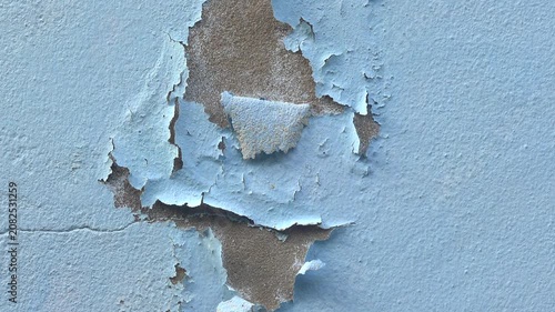 The paint is peeling off the concrete wall of house