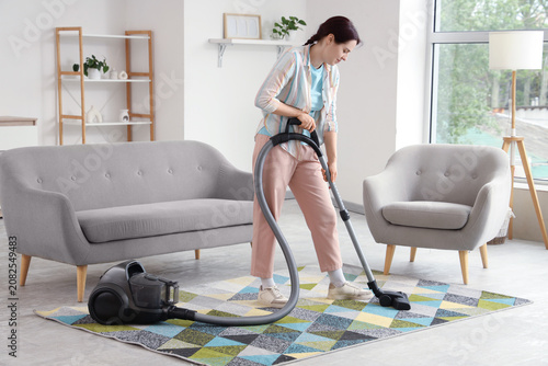 Woman vacuuming colorful ru...
