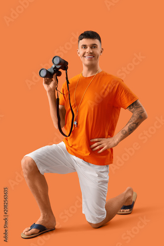Male lifeguard with binocul...