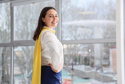 Superhero businesswoman near window in office
