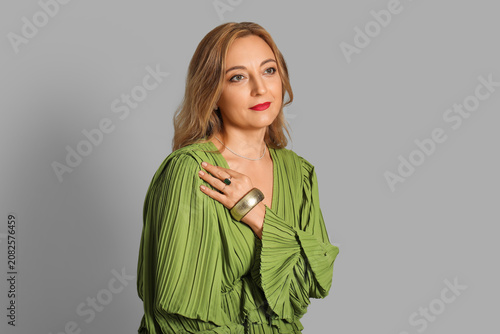 Beautiful mature woman with stylish accessories on grey background
