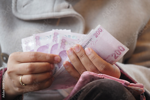 Konstfotografi Person counts turkish lira money in currency denomination in their hands