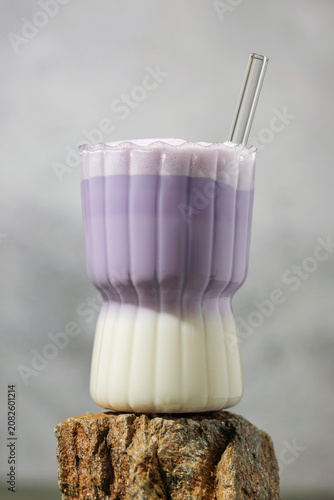 Ube latte in glass on the stone. Healthy vegan drink. Viral trendy asian beverage
