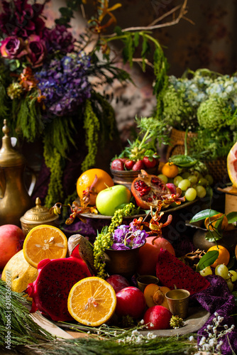 Colorful gourmet fruit still life featuring fresh tropical and citrus fruits arranged with decorative tableware