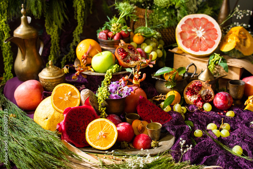 Colorful gourmet fruit still life featuring fresh tropical and citrus fruits arranged with decorative tableware