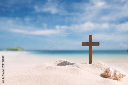 Fotografie Seashells and the Cross of Jesus Christ on a sandy beach, background for church