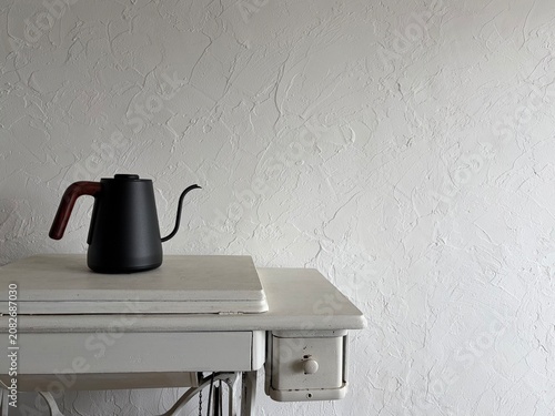 Slika na platnu Minimal black gooseneck kettle on vintage white drawer with plaster wall backgro