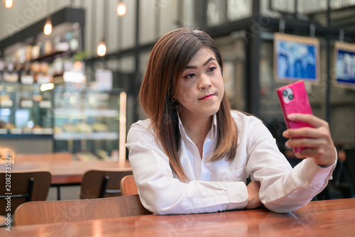 Foto Smiling Isan Thai Transgender Woman Taking Selfie with Phone at Coffee Shop with