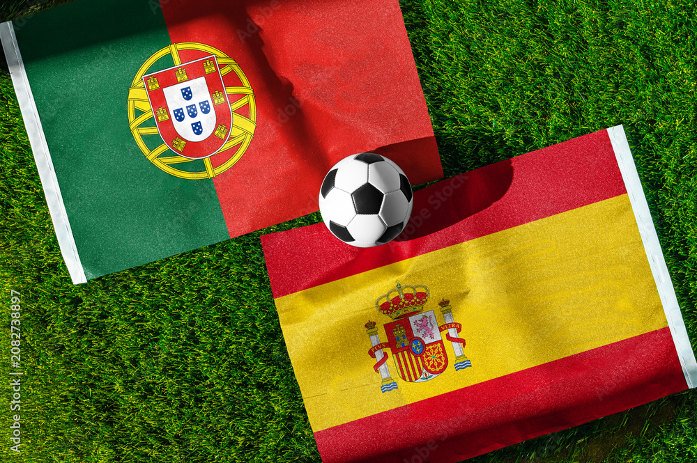 Fototapeta premium Portugal vs Spain, Round of 16, national flags before international football match, football on green grass with stadium in the background