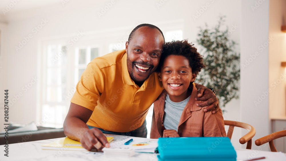 Obraz premium Father, portrait and student son in home for education, homework help or learning together. Hug, notebook and school assignment with family at kitchen counter in apartment for development or support