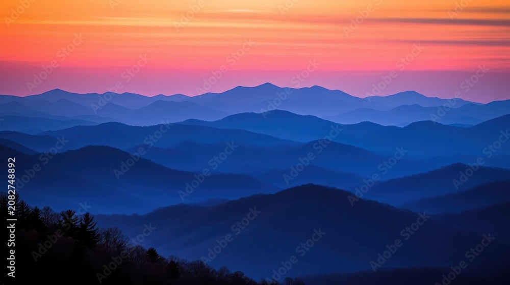 Fototapeta premium Majestic mountain ranges bathed in the soft glow of a colorful sunrise with layered peaks against a vibrant sky
