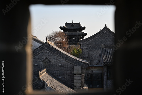 Fotografie Spring blossoms frame Qing-style gatehouse, its ornate eaves standing proud amid neighboring replicas