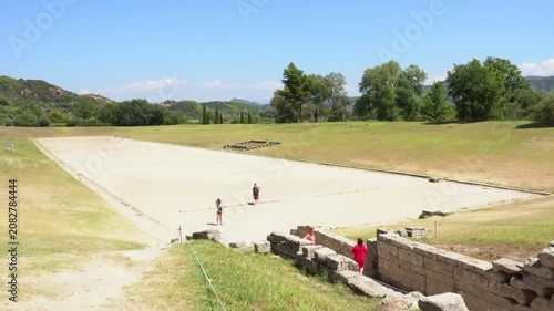 People visiting the ancient stadium of Olympia in Greece