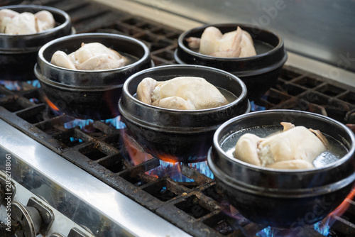 Canvastavla Korean traditional healthy chicken soup Samgyetang boiling in black earthen pots on a gas stove at Dongmyo Flea Market in Seoul
