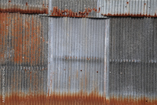 Artistic of old and rusty zinc sheet wall. Vintage style metal sheet roof texture. Pattern of old metal sheet. Rusting metal or siding. Corrosion of galvanized. Background and texture in retro concept
