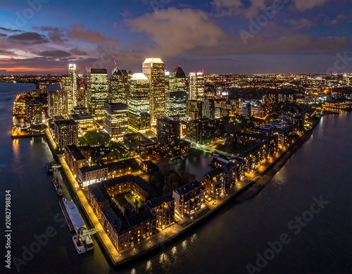 Modern cityscape at dusk with illuminated buildings and waterways