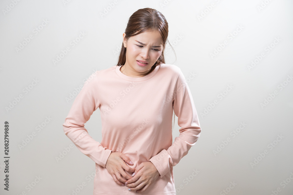 Obraz premium Flatulence asian young woman intolerance hand in stomach ache, suffer from food poisoning, abdominal pain and colon problem, gastritis or diarrhoea when at home. Patient belly, abdomen or inflammation