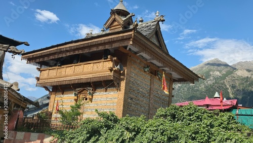 Side view highlights detailed wooden carvings and stone walls of historic Himalayan temple.