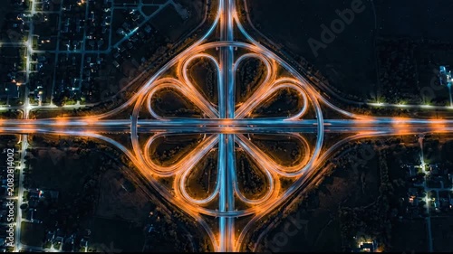Flower shaped glowing highway interchange at night.