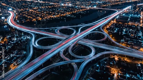 Illuminated urban highway loops at night from above.