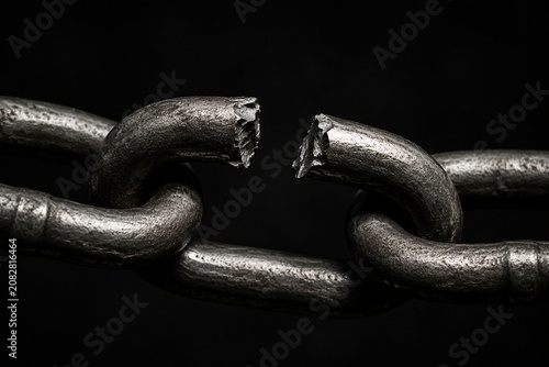 A close-up of a single broken metal chain link.