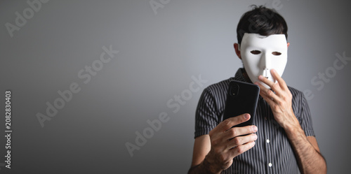 Cuadro en lienzo Man with a white mask using smartphone.
