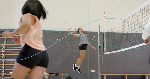 Photos Player in gray top jumping spiking volleyball at net on coach signaling during d