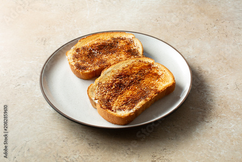 A view of some vegemite toast, on a plate.