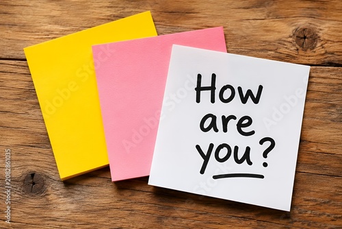 Handwritten How Are You Question on Sticky Note with Colored Pads