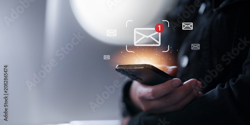 Cropped hands holding smartphone with digital email notification icons for mobile communication