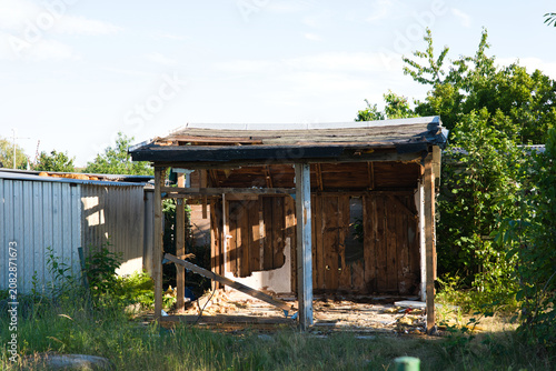Old damaged garden shed during demolition or renovation. Authentic wooden structure showing decay, reconstruction and abandonment.