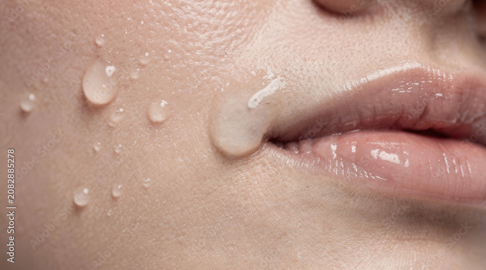Naklejka premium Close-up of hydrating face serum application on clean skin for beauty and skincare treatment