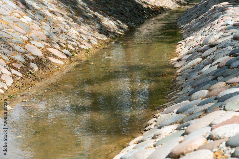 Foto Stone-Lined Water Channel with Flowing Stream