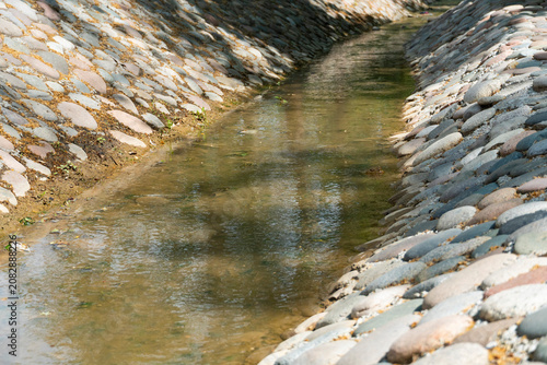 Foto Stone-Lined Water Channel with Flowing Stream