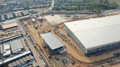 Foto Construction Site Overview: An aerial view showcases a sprawling construction site with large warehouses and ongoing development, highlighting industrial growth and infrastructure expansion